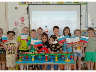 Дети возле макета крымского моста с флагами России